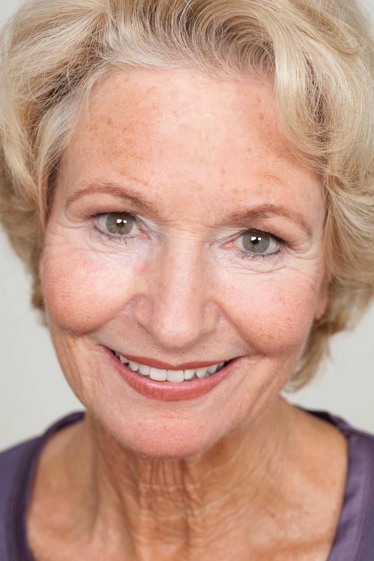 A smiling woman with her chin in her hand