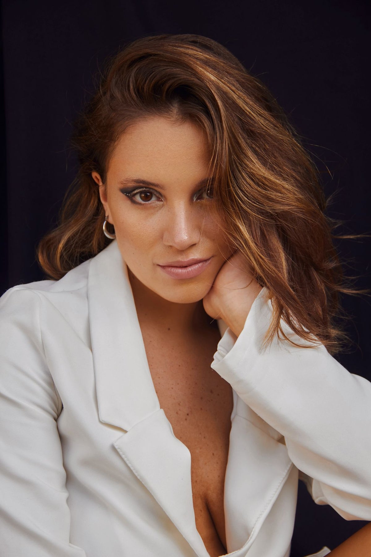 A confident woman in a white blazer